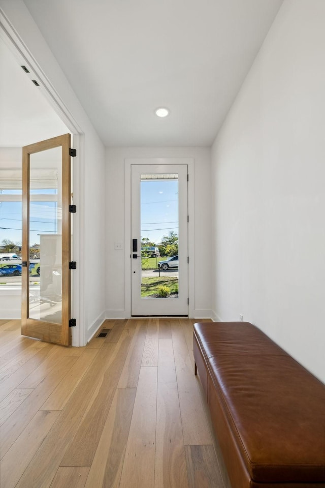 doorway with french doors and light hardwood / wood-style flooring