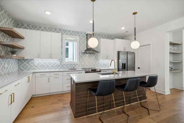 kitchen with pendant lighting, white cabinetry, sink, and stainless steel appliances