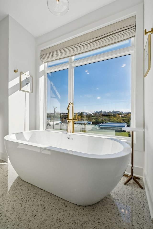 bathroom featuring a tub, sink, and a water view