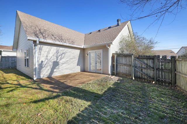 back of house featuring a lawn, a patio, and french doors