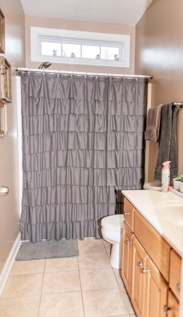 bathroom featuring toilet, vanity, tile patterned flooring, and curtained shower