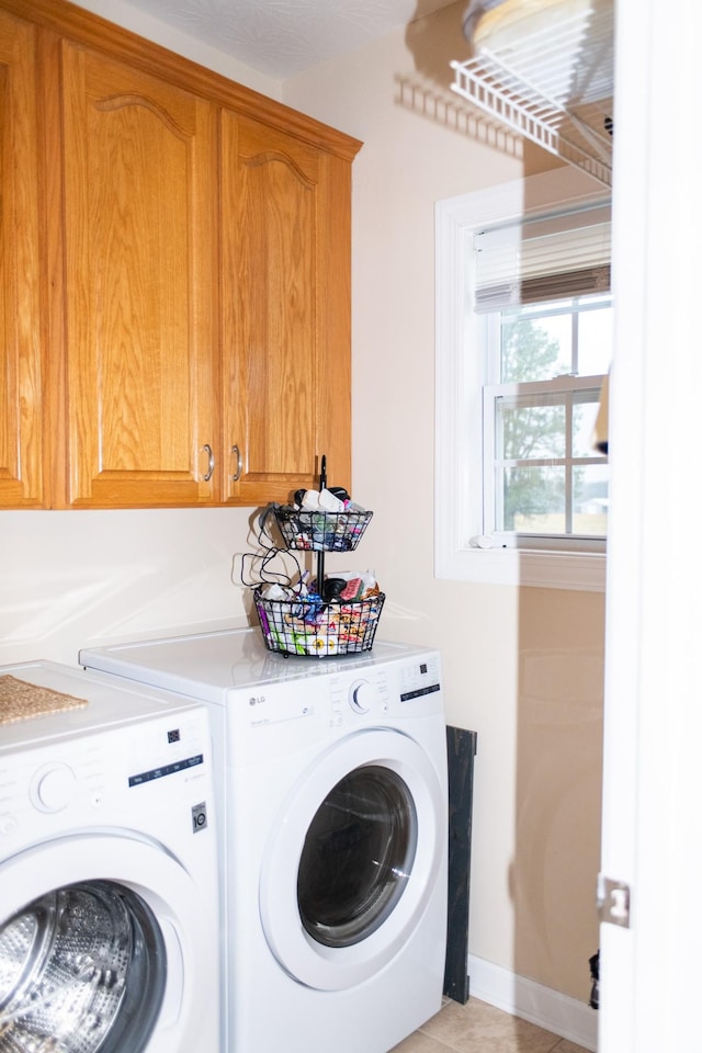 washroom featuring cabinets, separate washer and dryer, and light tile patterned floors