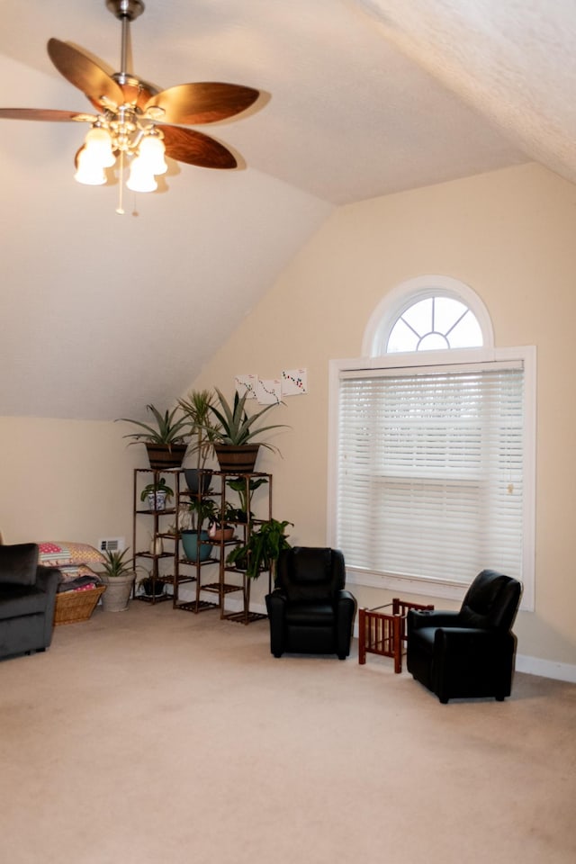 sitting room with ceiling fan, carpet flooring, and lofted ceiling