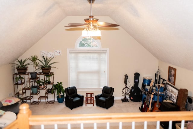 living area with ceiling fan, vaulted ceiling, and carpet flooring