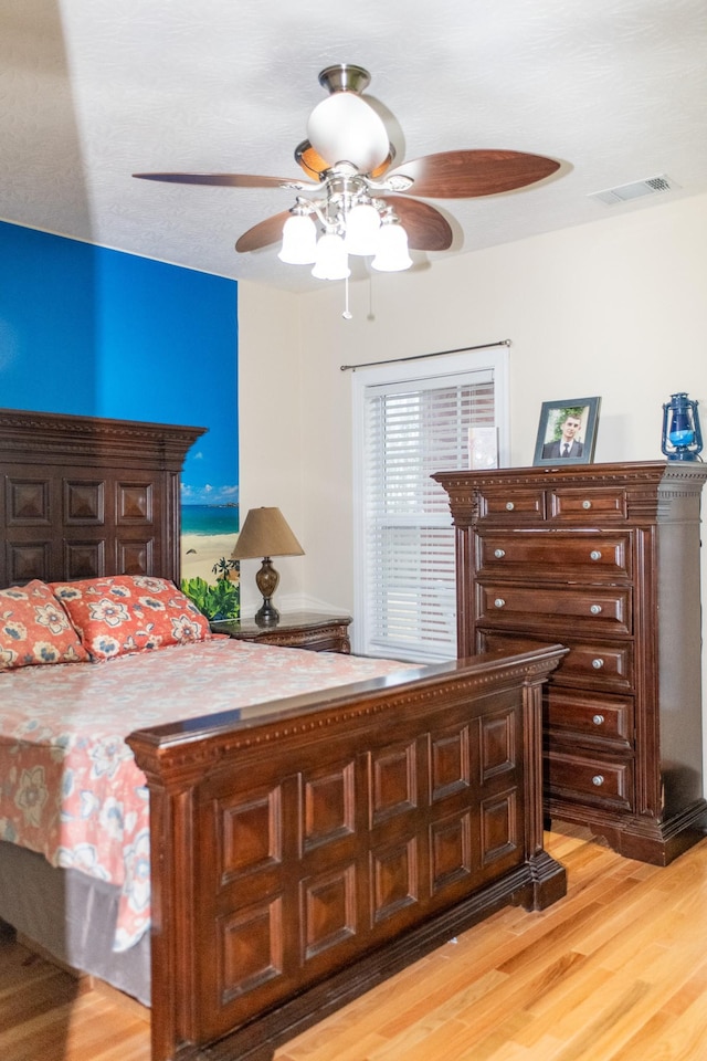 bedroom with ceiling fan and light hardwood / wood-style floors