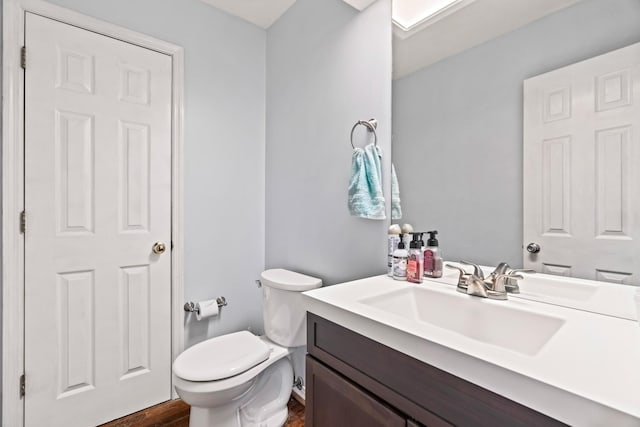 bathroom with vanity, hardwood / wood-style flooring, and toilet