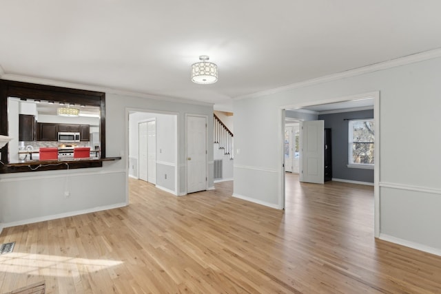 living room featuring light wood-type flooring and ornamental molding