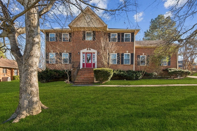 colonial inspired home featuring a front lawn