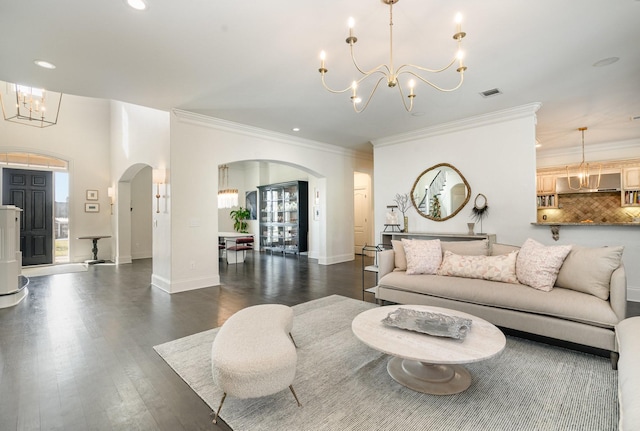 living room featuring an inviting chandelier, ornamental molding, and dark hardwood / wood-style flooring