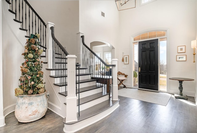 entryway featuring a towering ceiling and dark hardwood / wood-style floors