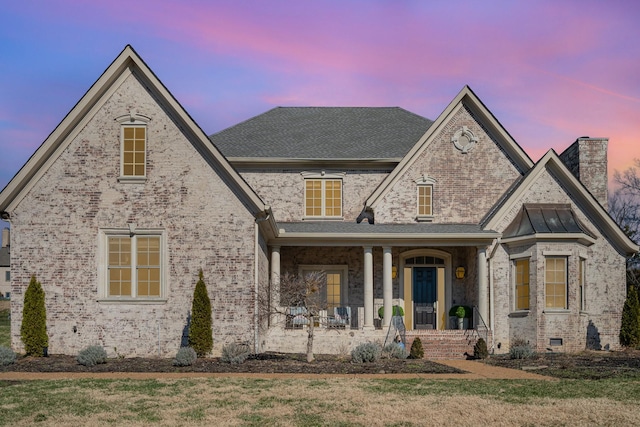 view of front of house with a porch and a lawn