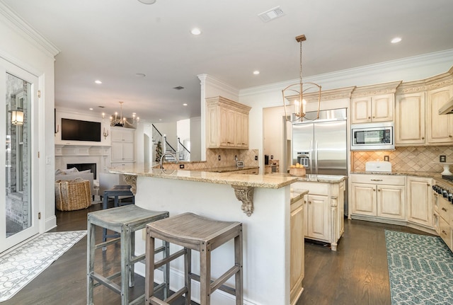 kitchen featuring built in appliances, dark wood-type flooring, and a breakfast bar area