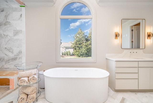 bathroom with ornamental molding, a washtub, and vanity