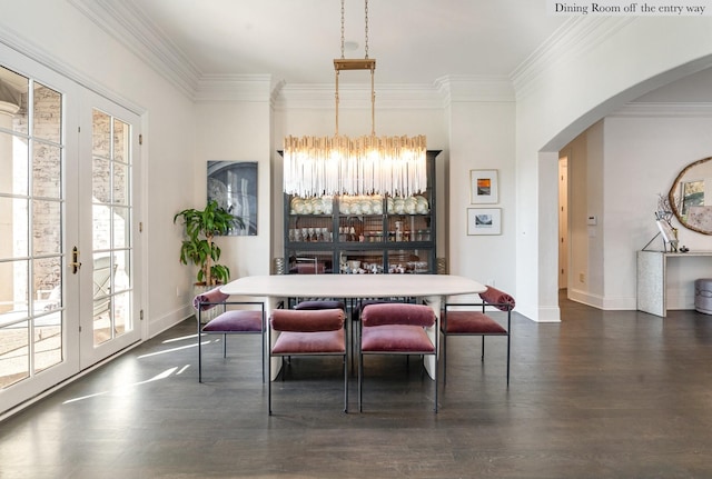 dining area with ornamental molding, an inviting chandelier, french doors, and dark hardwood / wood-style floors