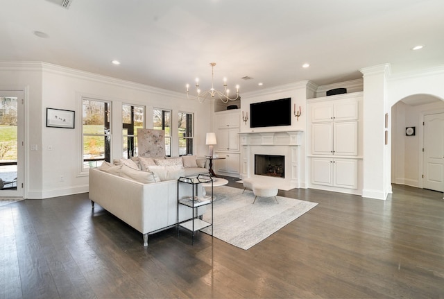 living room with crown molding, a chandelier, and dark hardwood / wood-style floors