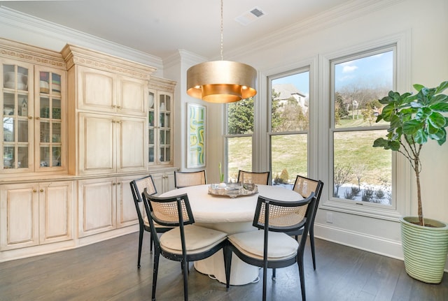 dining room featuring dark wood-type flooring and crown molding