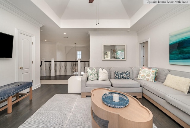 living room featuring a raised ceiling, ceiling fan, ornamental molding, and dark hardwood / wood-style floors