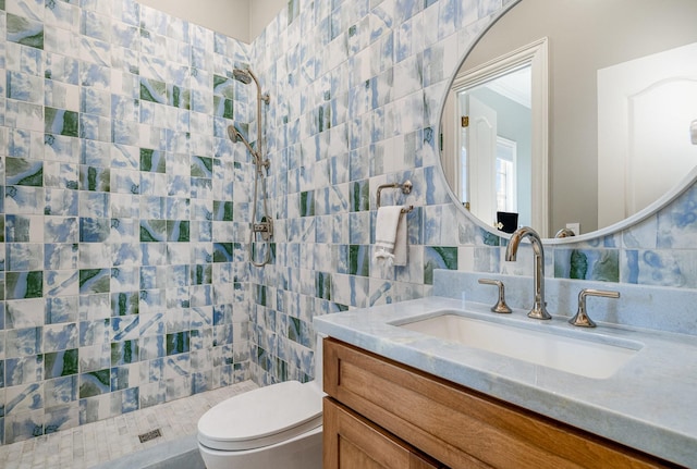 bathroom featuring tile walls, a tile shower, toilet, backsplash, and vanity