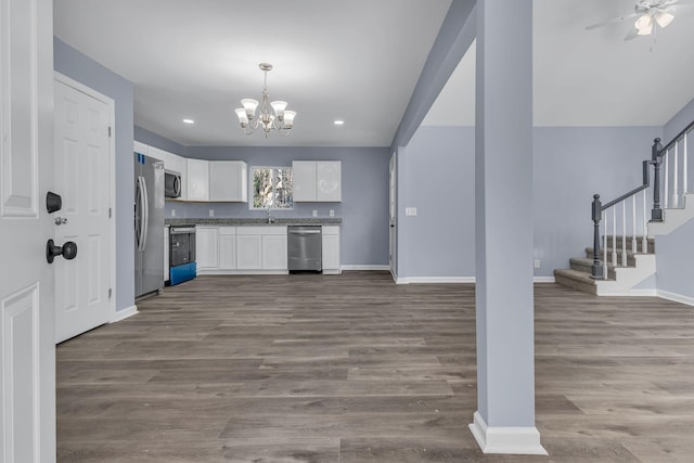 kitchen featuring stainless steel appliances, hardwood / wood-style flooring, white cabinets, decorative light fixtures, and ceiling fan with notable chandelier