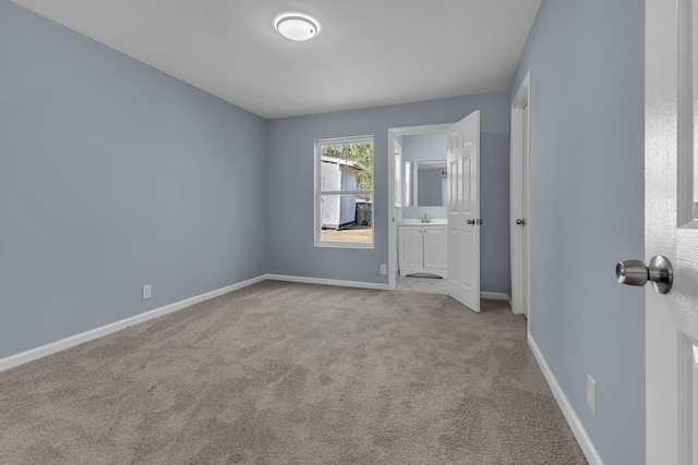 unfurnished bedroom featuring connected bathroom and light carpet