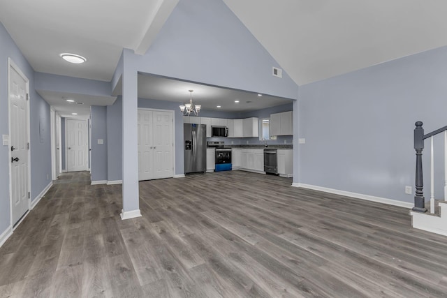 unfurnished living room featuring hardwood / wood-style floors, high vaulted ceiling, and a chandelier