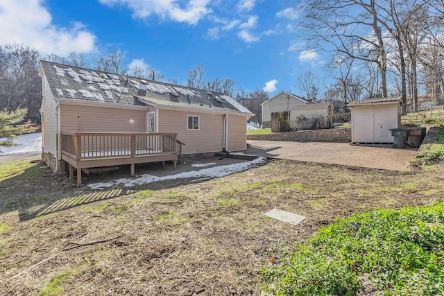 rear view of house with a deck and a storage shed