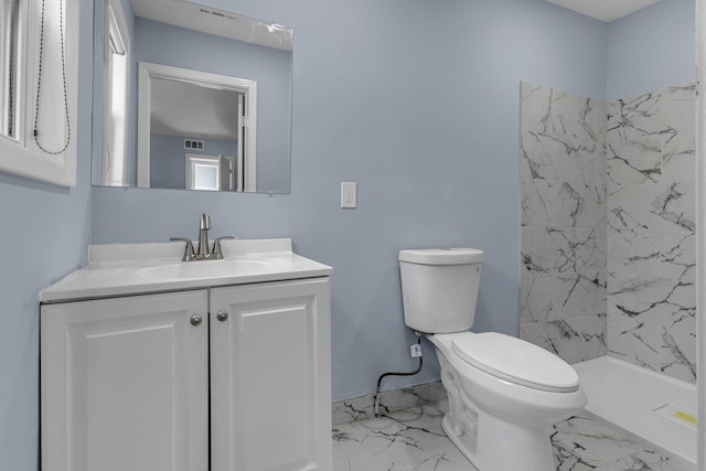 bathroom featuring toilet, vanity, and walk in shower