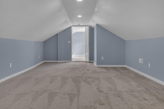 additional living space with light carpet and lofted ceiling