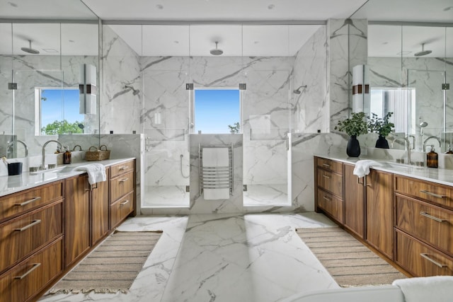 bathroom featuring vanity, a shower with shower door, and tile walls