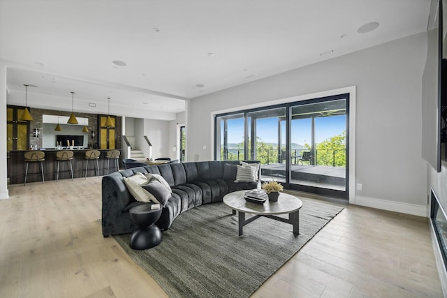 living room with bar and light wood-type flooring