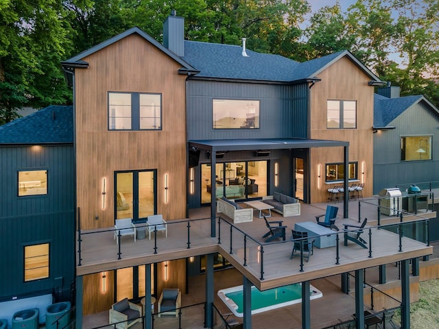 back of house with outdoor lounge area, a swimming pool, and a patio