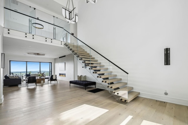 stairway featuring wood-type flooring and a towering ceiling