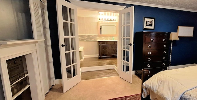 bedroom featuring french doors, carpet flooring, ornamental molding, a textured ceiling, and a closet