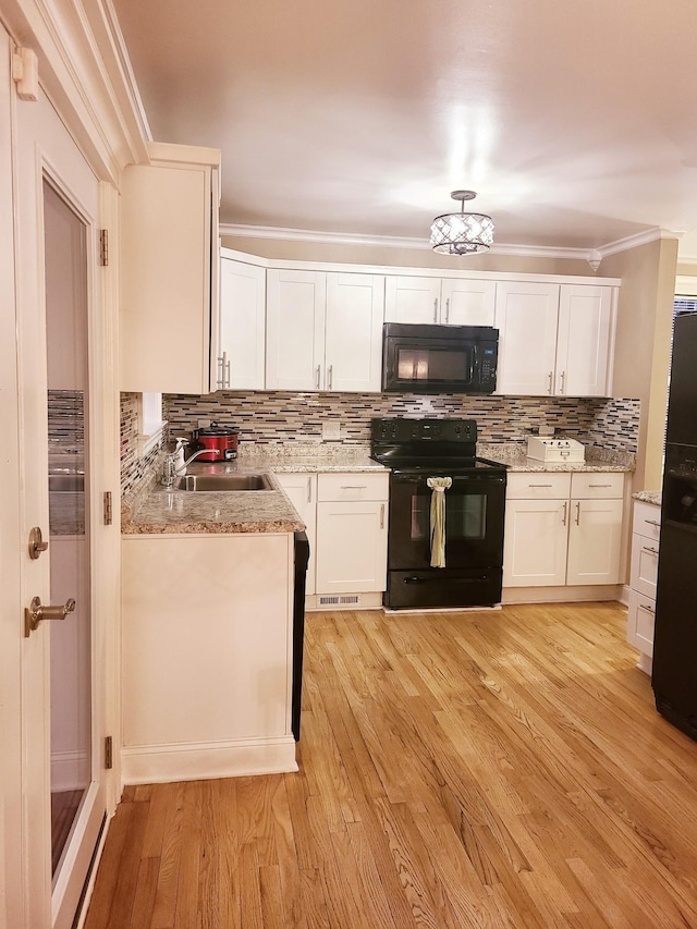 kitchen with black appliances, crown molding, sink, light hardwood / wood-style floors, and white cabinetry