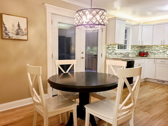 dining area featuring sink and light wood-type flooring