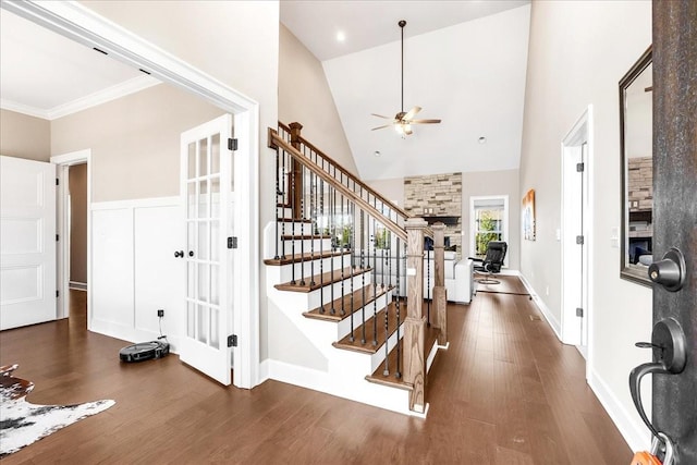 entryway with ceiling fan, dark hardwood / wood-style flooring, high vaulted ceiling, and crown molding