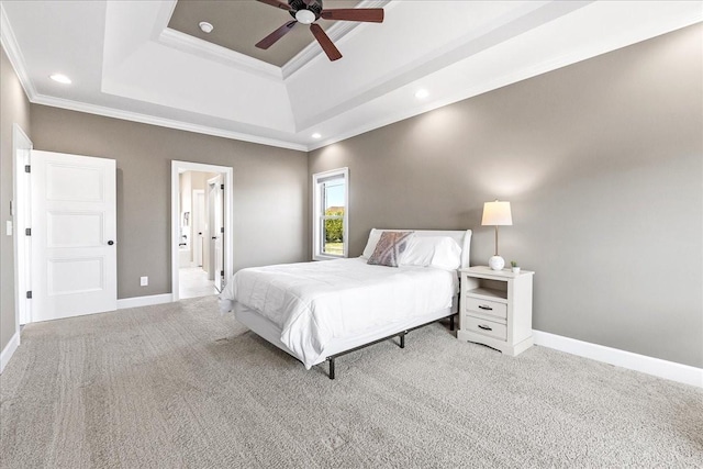 bedroom featuring ceiling fan, crown molding, light carpet, and a tray ceiling