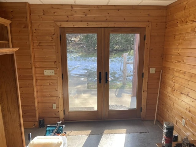 doorway with wooden walls and french doors