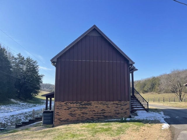 view of home's exterior with a rural view and central air condition unit