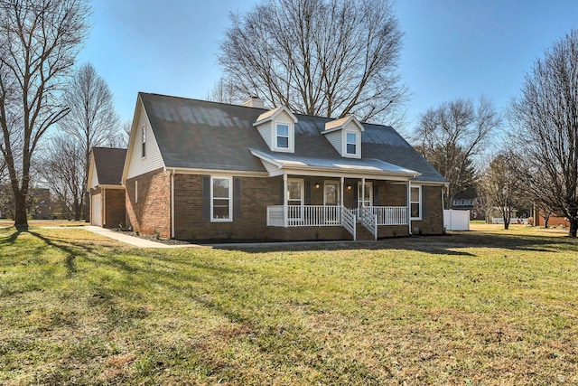 new england style home with covered porch, a front yard, and a garage