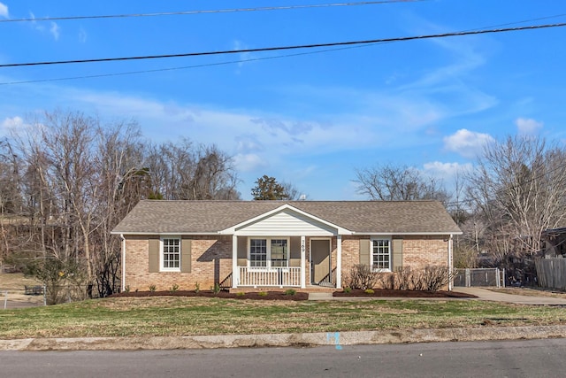 ranch-style home featuring a front lawn and covered porch