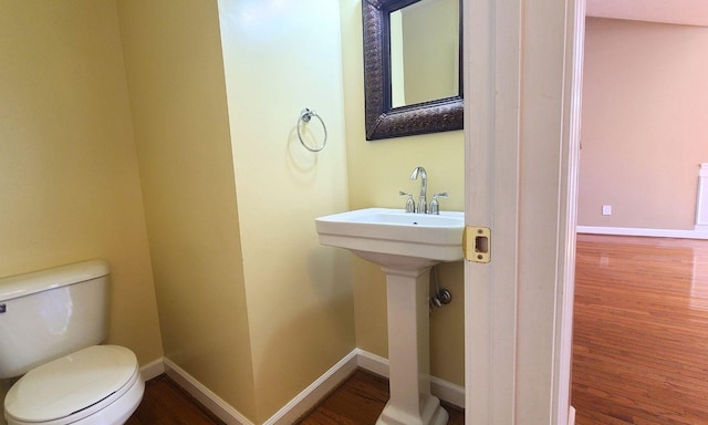 bathroom featuring wood-type flooring and toilet