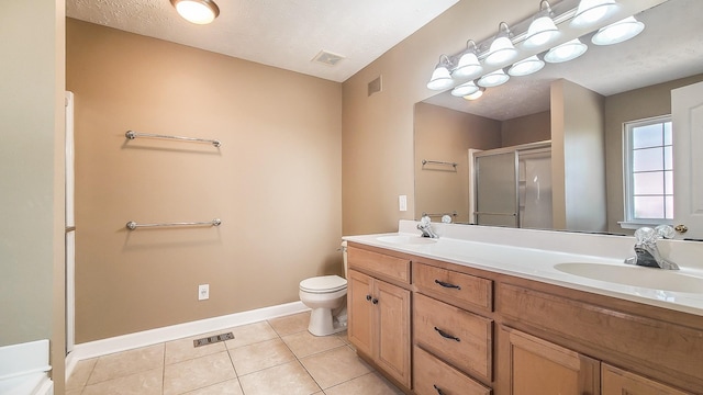 bathroom with vanity, toilet, an enclosed shower, and tile patterned flooring