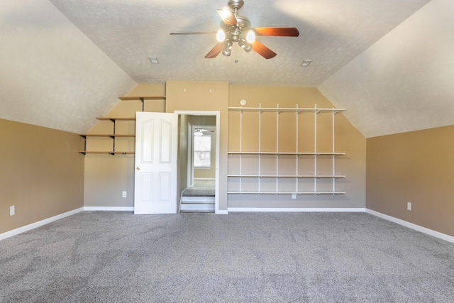 additional living space with lofted ceiling, carpet flooring, a textured ceiling, and ceiling fan