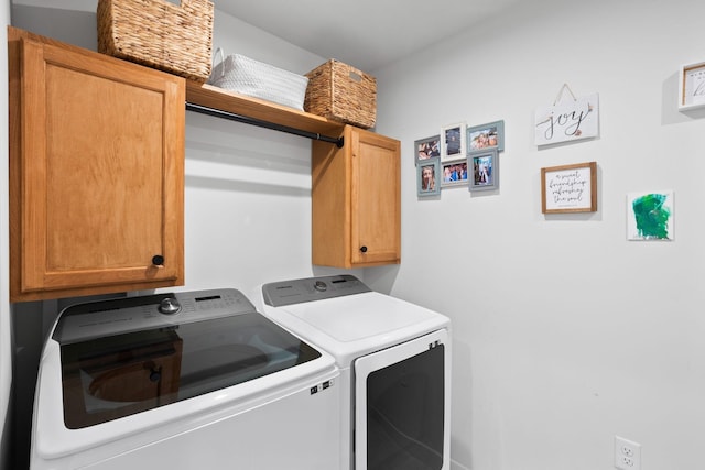 laundry room with separate washer and dryer and cabinets