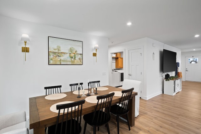 dining room with light hardwood / wood-style floors and independent washer and dryer