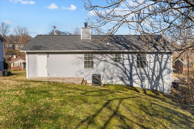 rear view of property with central AC unit, a yard, and a patio