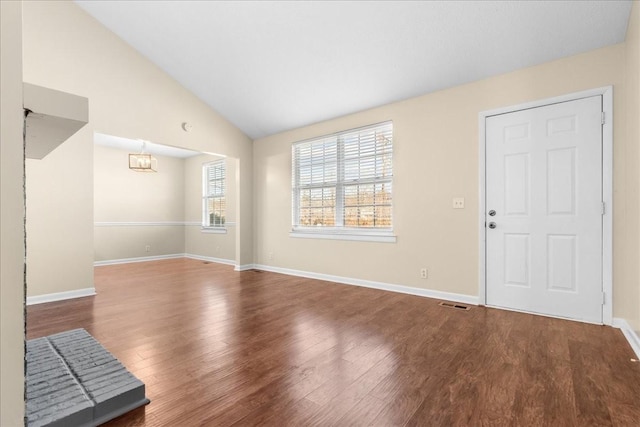 interior space with a notable chandelier, vaulted ceiling, and hardwood / wood-style flooring