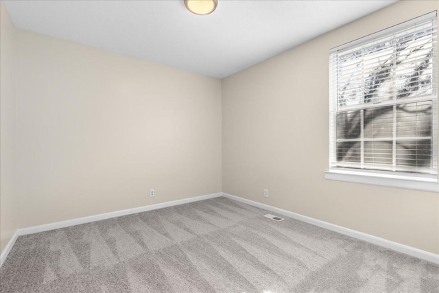 unfurnished room featuring light carpet