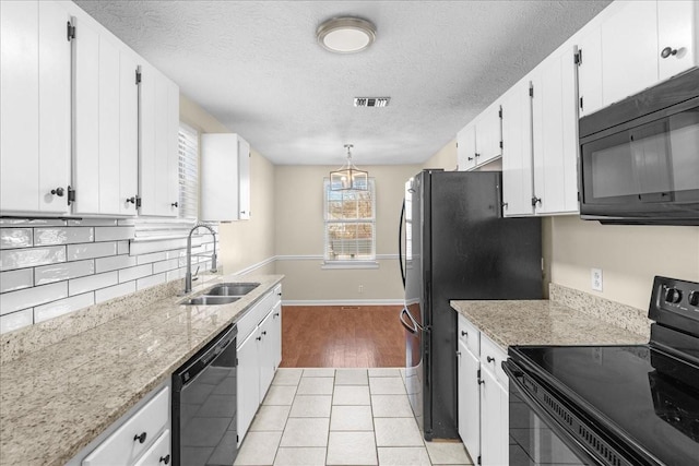 kitchen featuring pendant lighting, sink, white cabinetry, and black appliances